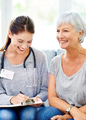 A nurse talking with a smiling senior resident
