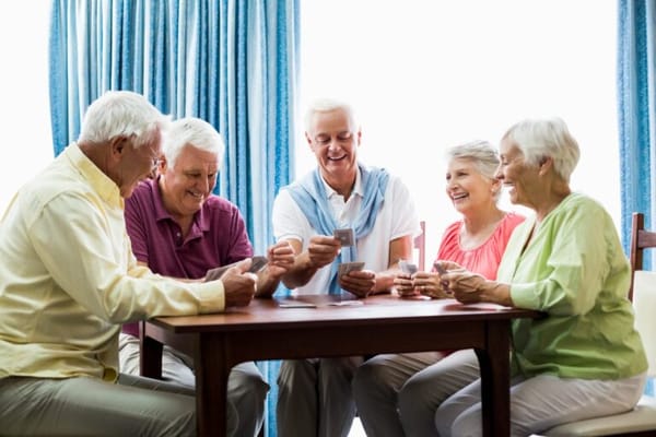 Seniors enjoying a card game in a bright room