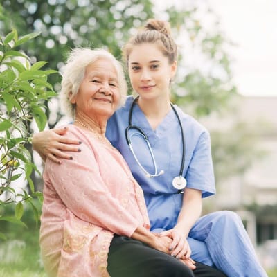Nurse with elderly resident in a garden setting