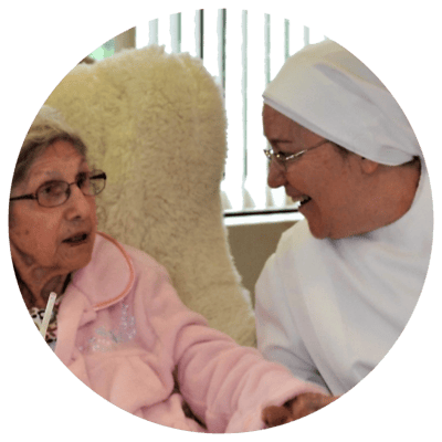 A caregiver interacting with a resident in a cozy setting