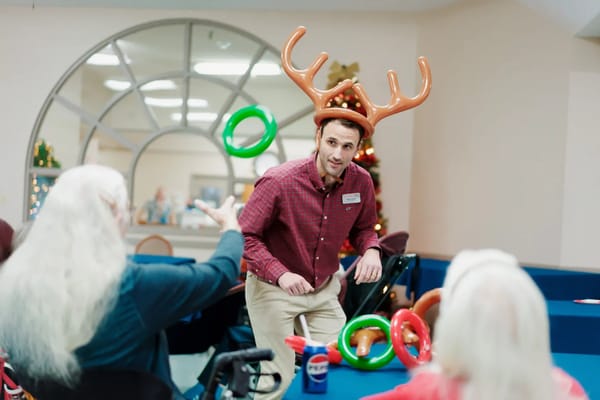 Staff member engaging residents in a festive activity