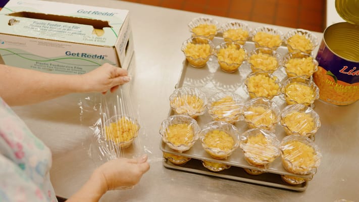 Preparing dessert cups in a kitchen setting