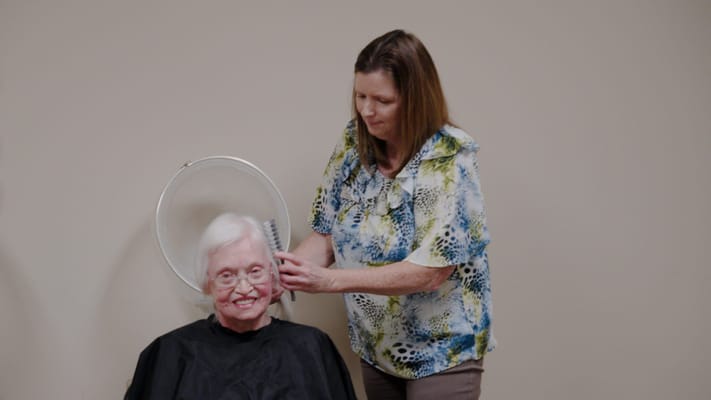 A resident receiving a hair treatment in a salon
