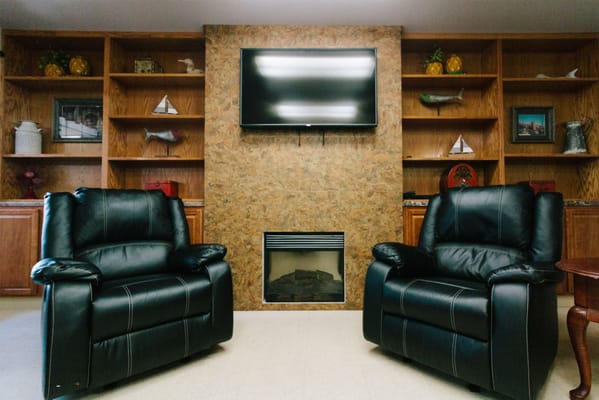 Cozy common area with leather chairs and TV
