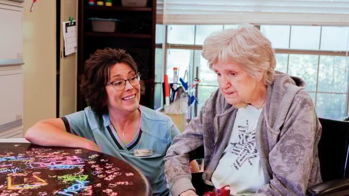 Staff member engaging with a resident at a table