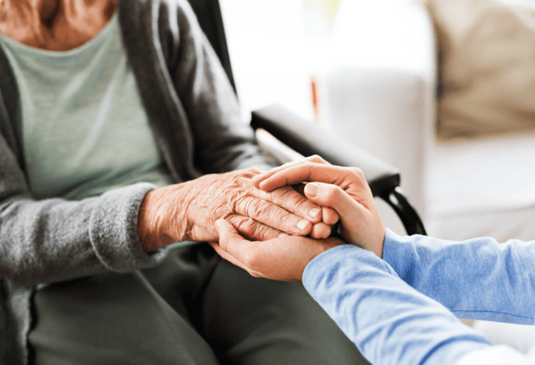Caregiver holding a resident's hand