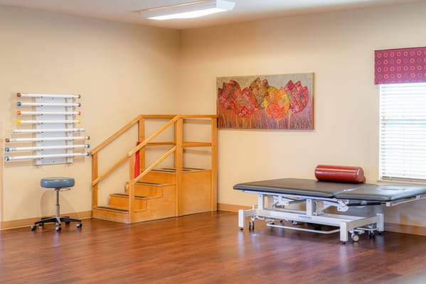 Therapy room with equipment and colorful artwork