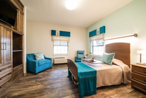 Bright, well-furnished resident room with a bed and seating area