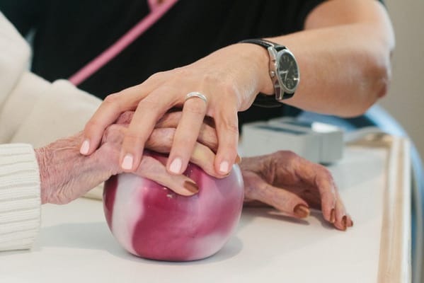 Hands of a caregiver and a resident engaged in activity