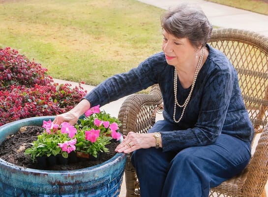 Resident gardening with pink flowers in an outdoor space
