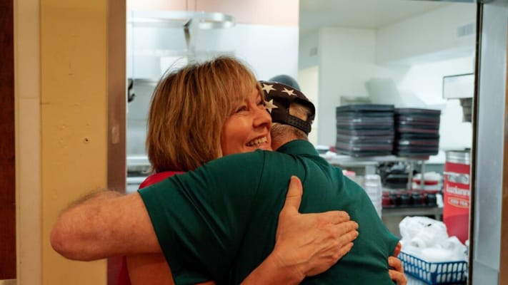 Residents sharing a warm hug in a kitchen