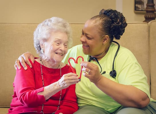 A caregiver and resident sharing a joyful moment indoors