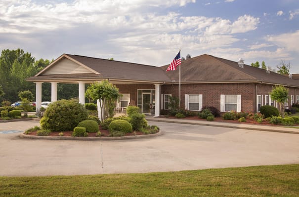 Exterior view of a senior living facility with gardens