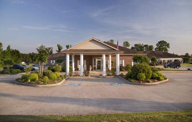 Front entrance of a senior living facility with gardens