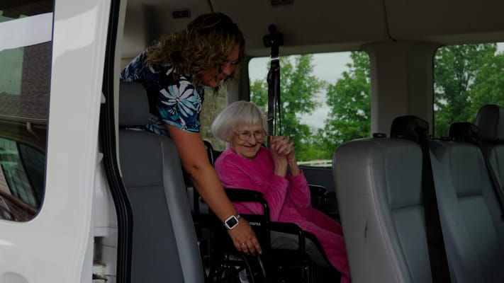 Staff assisting a resident in a wheelchair