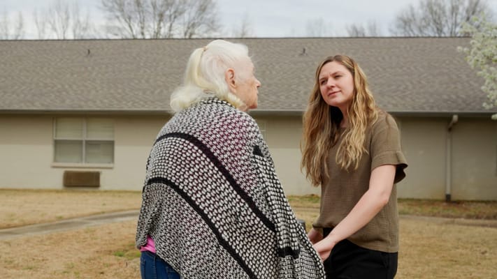 Caregiver interacting with a senior in a garden area