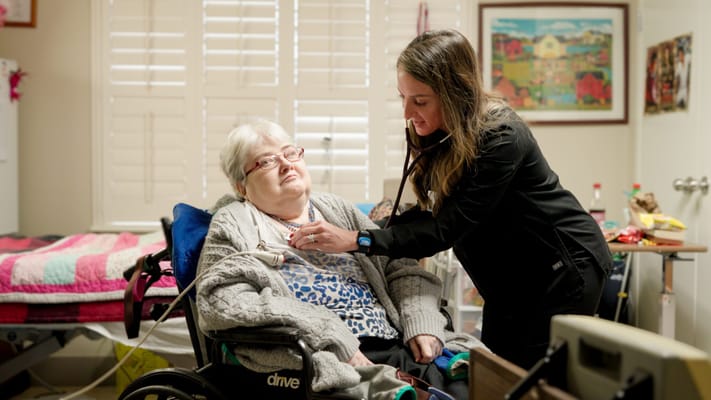 Staff member attending to a resident in a room