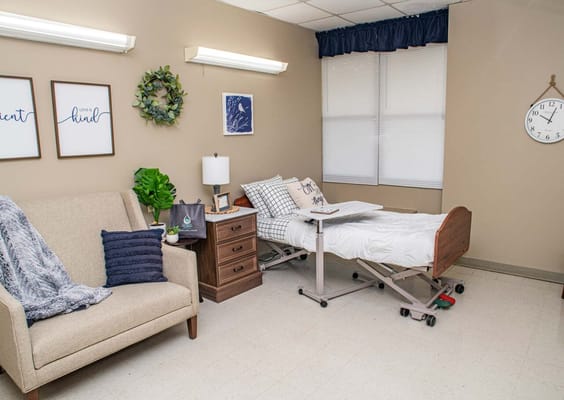 A cozy senior living room with a hospital bed and furniture