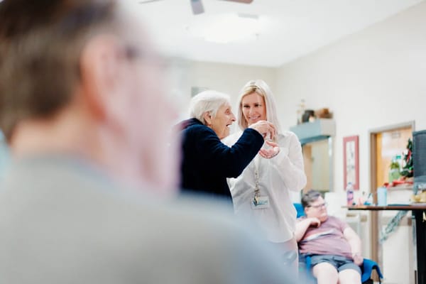 Residents engaging in an activity with staff assistance