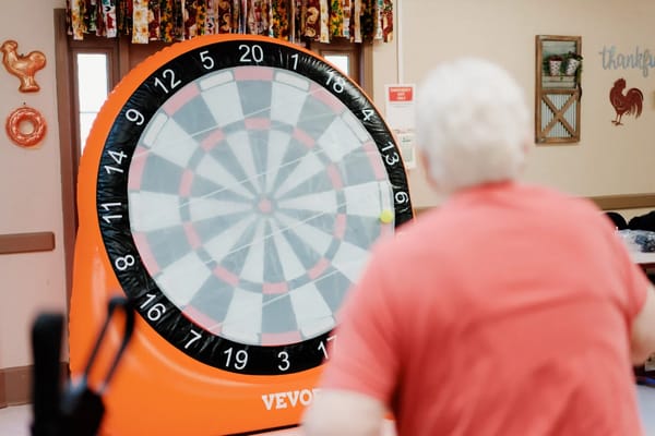Residents enjoying a game of dart toss indoors