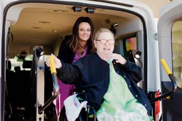 Caregiver assisting a resident in a vehicle