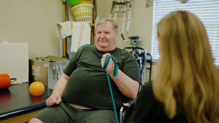 Resident engaging in physical therapy session with staff