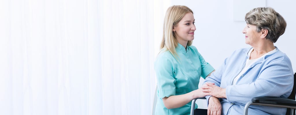 Nurse and resident engaging in conversation in a bright room