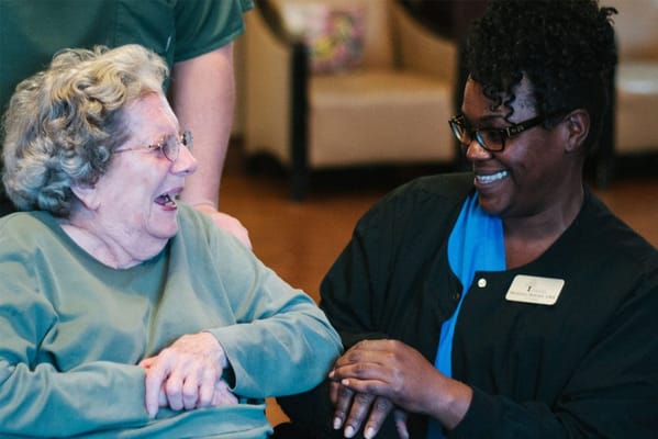 A caregiver and resident smiling and enjoying a moment