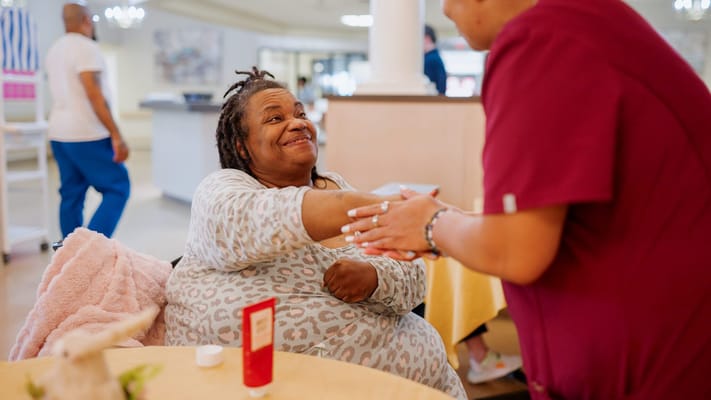 Resident interacting with staff in a common area