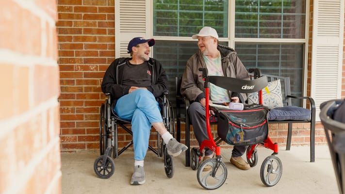 Residents enjoying conversation outdoors in wheelchairs