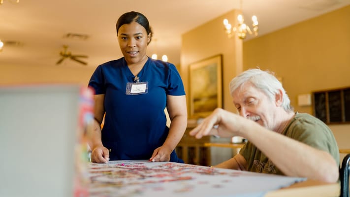 Staff assisting a resident with a puzzle activity