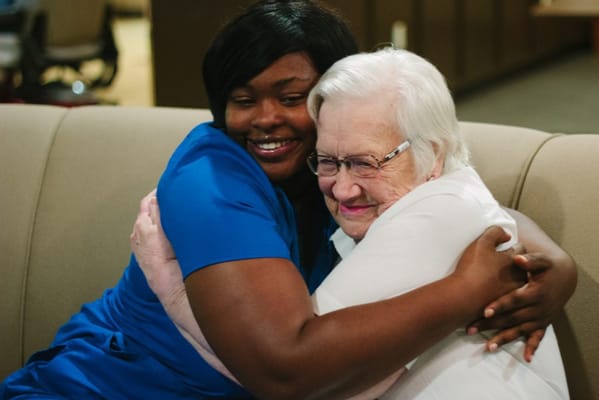 A caregiver and a resident sharing a warm embrace