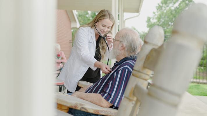 Healthcare professional assisting a senior outdoors