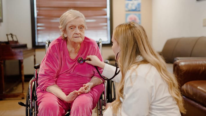 A caregiver checking a patient's heartbeat in a cozy room