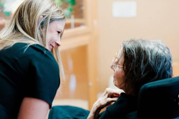 Staff interacting warmly with a resident in a cozy setting