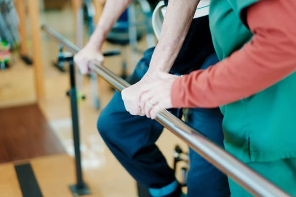 Caregiver assisting a resident with rehab exercises