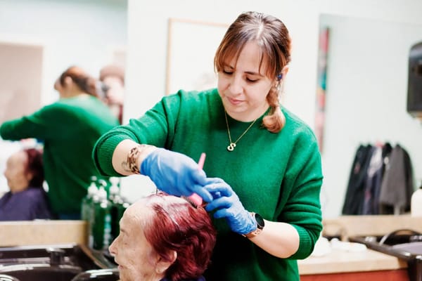 Staff providing hair services to a resident
