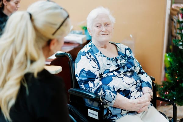 A resident smiling while talking to a staff member