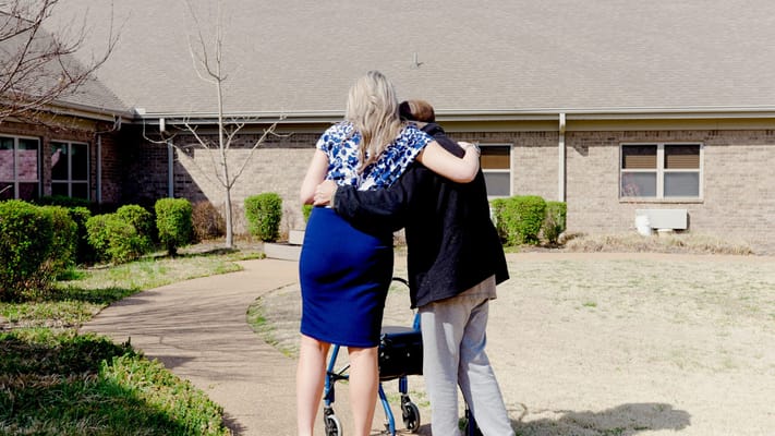 Caregiver assisting a resident outside the facility