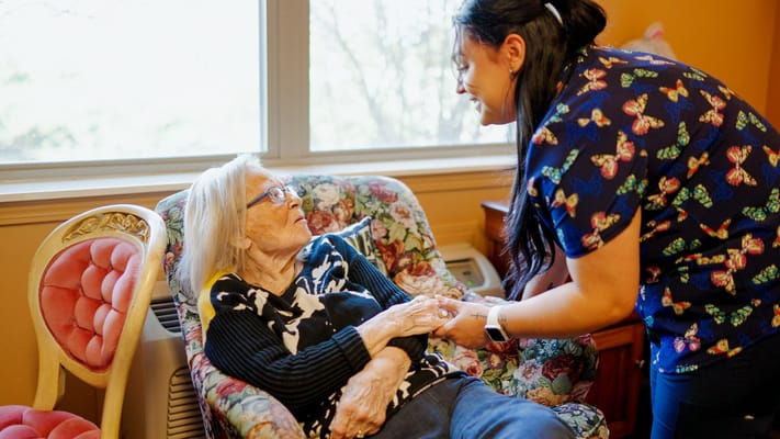 Caregiver assisting a resident in a cozy room