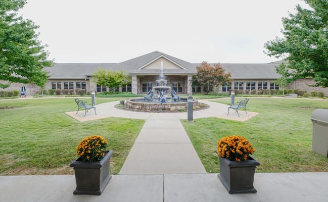 Exterior view of a senior living facility with a fountain