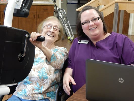 A resident and staff member smiling together during an activity