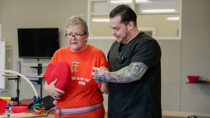 Staff assisting a resident during therapy session