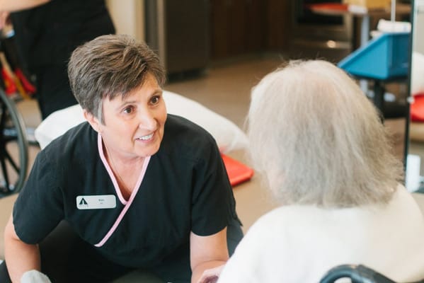 Staff member assisting a resident in a bright interior