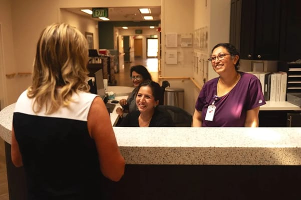 Staff welcoming a visitor at the reception desk
