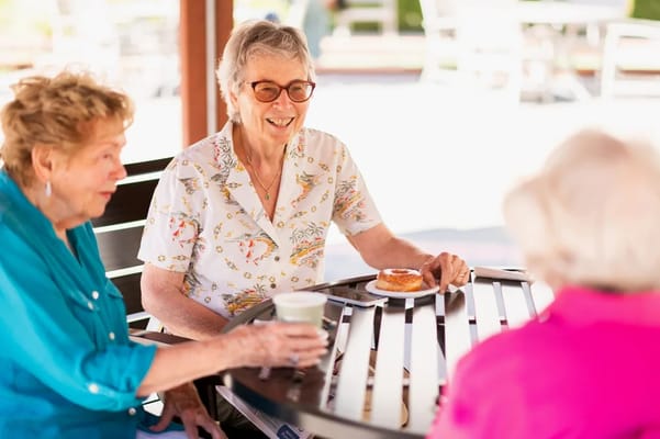 Residents enjoying pastries and drinks at an outdoor table