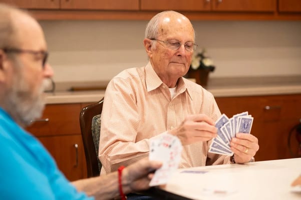 Two seniors playing cards at a table