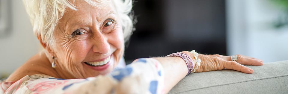 A smiling senior woman sitting indoors