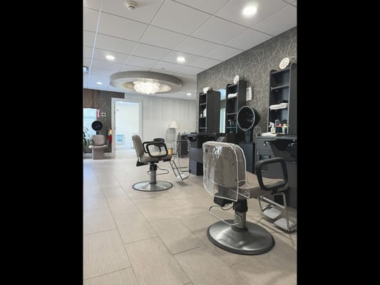 Hair salon area with styling chairs and mirrors