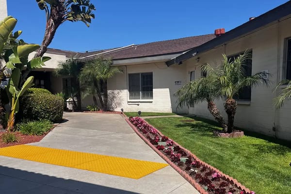 Pathway leading to a facility with landscaped gardens